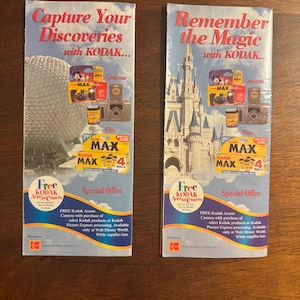 K&ouml;nnte beinhalten: Zwei Vintage-Kodak-Brosch&uuml;ren. Eine zeigt "Capture Your Discoveries" mit einem Bild einer geod&auml;tischen Kugel. Die andere sagt "Remember the Magic" mit einem Schlossbild. Beide Brosch&uuml;ren werben f&uuml;r Kodak-Kameras und -Filme.