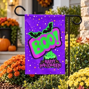 Op de afbeelding: Een rechthoekige paarse tuin vlag met een felgroene BOO!-afbeelding, zwarte vleermuizen erboven en een borrelende groene ketel eronder. De tekst Happy Halloween is in het zwart onder de ketel gedrukt op een paarse achtergrond.