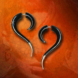 May include: A pair of black horn earrings with a curved design. The earrings are made of polished black horn and have a silver-toned post.