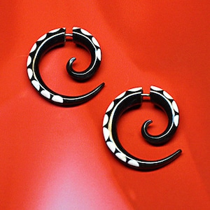 May include: A pair of black and white spiral earrings. The earrings are made of horn and have a white dot pattern.