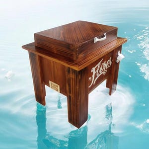 May include: A wooden cooler with a dark brown finish, featuring a rectangular box on top and a lower compartment with the word "Flores" in white script. It has a white bottle opener and a small handle on the box.