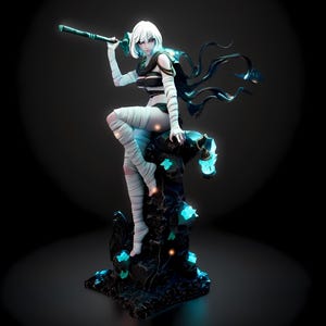May include: A 3D-rendered figurine of a female character with white hair, black and white attire, and wrapped bandages. She holds a staff and sits atop a dark, textured structure with glowing blue accents. The figure has a flowing black cape.