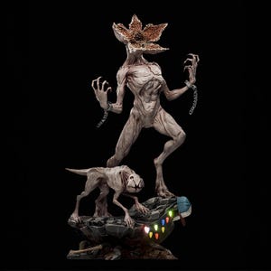 May include: A detailed statue of the Demogorgon from Stranger Things, with a large, flower-like head and chained wrists. A smaller creature stands below, with a base featuring Christmas lights and a hat.