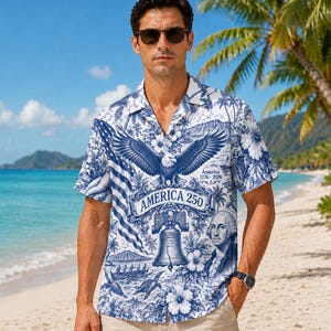 Puede incluir: Una camisa de manga corta con un diseño patriótico azul y blanco. La camisa presenta un águila, la Campana de la Libertad y el texto "America 250". El diseño también incluye imágenes de la bandera estadounidense y George Washington.
