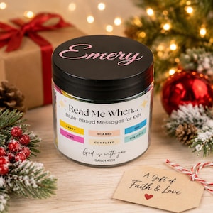 May include: A clear glass jar with a black lid featuring the name Emery in pink script. The label reads Read Me When... Bible-Based Messages for Kids with color-coded boxes for emotions like happy, sad, mad, scared, thankful, and confused.
