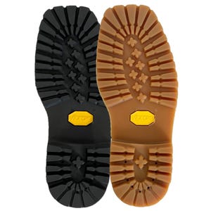 May include: Two rubber boot outsoles with deep lug patterns for traction. One sole is solid black and the other is a translucent tan colour. Both feature a prominent yellow Vibram logo embedded in the centre of the arch area of the sole.