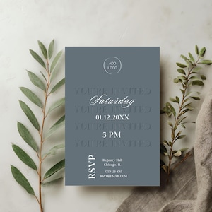 Może przedstawiać: Formalna karta zaproszenia w stonowanym niebiesko-szarym kolorze. Karta zawiera wytłoczony tekst z napisem "You're Invited" oraz szczegóły wydarzenia, w tym "Saturday", datę i godzinę. Miejsce na logo znajduje się u góry.