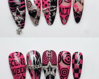 May include: A set of ten long, pointed artificial nails with a punk rock theme. Designs include black and pink zebra stripes, silver glitter, hearts, stars, safety pins, and the words "ALT" and "SCENE QUEEN".