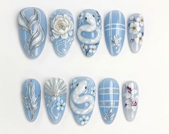 Blauwe slang bloemenpers op de nagels met zilveren details en geruite accenten – elegante handgemaakte nailart-set, esthetische slangmanicure