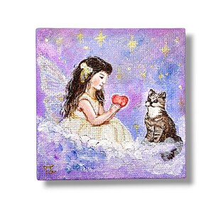 May include: A square painting depicts a young girl in a yellow dress holding a red heart, with a cat sitting nearby. The background is a starry purple sky with white clouds. The girl has long dark hair and a yellow bow.