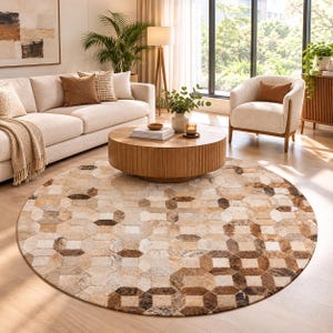 May include: A round area rug featuring a geometric pattern of interlocking octagons and squares in various shades of tan, beige, cream, and dark brown, constructed from individual pieces of textured hide with a natural hair-on finish.