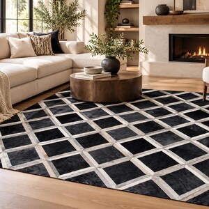 May include: A rectangular area rug featuring a repeating geometric pattern of black squares framed by light gray and white borders. The rug is constructed from stitched panels, creating a grid-like design that covers the entire surface area.