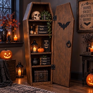 May include: A tall, wooden, coffin-shaped shelving unit with a hinged door featuring a black bat cutout and a circular ring handle. The interior shelves hold a human skull, books titled Potions, Spells, Enchantments, Trick or Treat, and Witches.