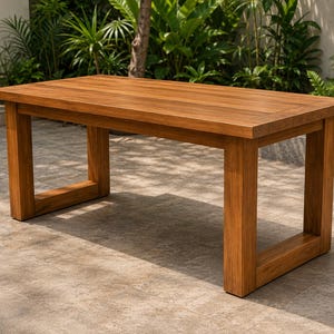 May include: A rectangular wooden dining table featuring a warm brown finish with a visible natural grain pattern. The table is constructed with a thick, flat tabletop surface supported by four sturdy, block-style legs connected by base rails.