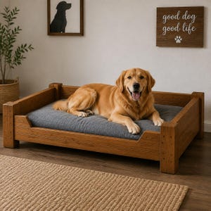 May include: A rectangular wooden dog bed frame with a medium brown finish and a thick, grey rectangular cushion. A golden retriever is lying on the cushion. The frame features sturdy corner posts and low side rails, providing a stable base for the pet.