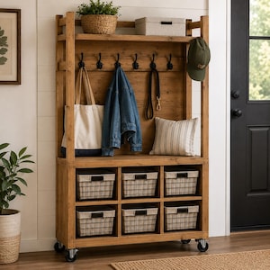 May include: A tall wooden entryway organizer on wheels featuring a top shelf with a woven basket and storage box, a middle section with six black hooks holding a tote bag, denim jacket, leash, and cap, and six lower cubbies with wire baskets.