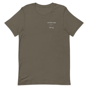 Puede incluir: Camiseta verde oliva con cuello redondo. La camiseta tiene el texto "connection makes the way" en escritura blanca sobre un gráfico de montaña. La camiseta está hecha de un material suave.