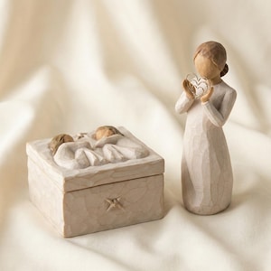 Könnte beinhalten: Eine beigefarbene dekorative Box mit Sternmuster und einem Deckel mit einem geschnitzten Relief von zwei Figuren. Eine Figur einer Frau in einem weißen Kleid, die ein herzförmiges Objekt hält, ist ebenfalls vorhanden.