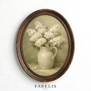 May include: Oval framed print featuring a still life of white lilacs in a cream-colored pitcher. The artwork has a vintage aesthetic, with a dark brown wooden frame. The text "FABELIS PRINTS" is printed at the bottom of the image.