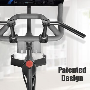 Puede incluir: Primer plano del manillar y la consola de una bicicleta est&aacute;tica. El manillar gris es curvo, con una barra recta que se extiende hacia la derecha. La consola muestra n&uacute;meros. El texto "Patented Design" es visible a la derecha.