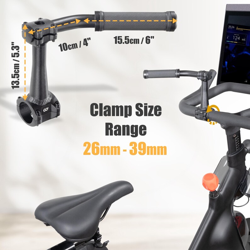 May include: Black exercise bike handlebar with measurements: 10cm/4", 15.5cm/6", and 13.5cm/5.3". The text "Clamp Size Range 26mm-39mm" is displayed. The image also shows a bike seat and a screen.