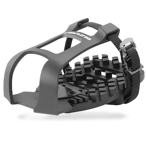 May include: A dark gray bicycle pedal with a black strap and buckle. The pedal has a cage-like design with a textured surface for grip. The brand name "onzzo" is visible on the top of the pedal.