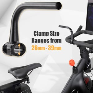 May include: Black exercise bike handlebar with a curved design. The clamp size ranges from 26mm to 39mm. The image also shows a black seat and other parts of the exercise bike.