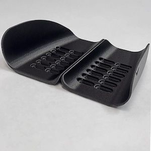 May include: A black, two-part plastic organizer tray with curved sides and a series of elongated, parallel slots for storage. The object features a textured surface and includes the text GAVILAND 3D SOLUTIONS in the bottom right corner.