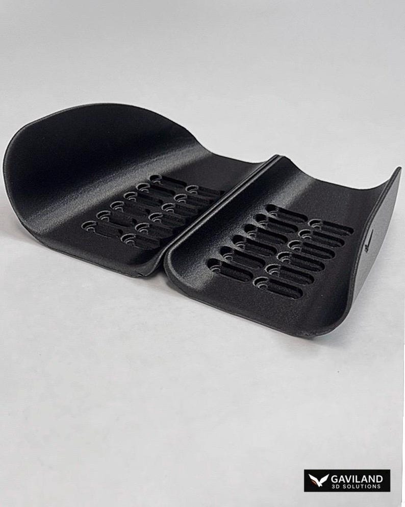 May include: A black, two-part plastic organizer tray with curved sides and a series of elongated, parallel slots for storage. The object features a textured surface and includes the text GAVILAND 3D SOLUTIONS in the bottom right corner.