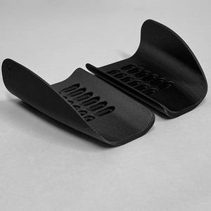 May include: A handmade, wooden serving tray with a natural finish. The tray features a rectangular shape with rounded corners and raised edges. It is designed with two handles for easy carrying. The wood grain is visible, adding to its rustic charm.