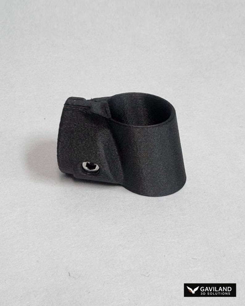 May include: A matte black, 3D-printed cylindrical pipe connector featuring a textured surface and a single integrated metal bolt head on the side. The component has a tapered design with a hollow center, designed for structural assembly and joining.