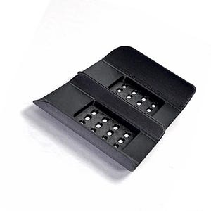 Puede incluir: Un soporte negro rectangular de pl&aacute;stico impreso en 3D que presenta dos secciones empotradas y perforadas con m&uacute;ltiples peque&ntilde;os agujeros cuadrados. El objeto tiene un acabado mate liso e incluye el texto GAVILAND 3D SOLUTIONS en la esquina.