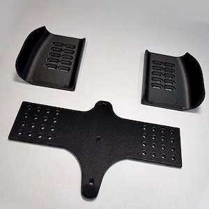 May include: Three black, textured, 3D-printed components. Two curved pieces with rectangular vents and a central, flat piece with multiple circular holes. The pieces are arranged on a white background.