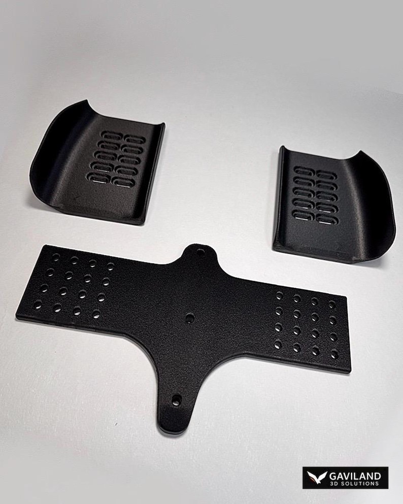 May include: Three black, textured, 3D-printed components. Two curved pieces with rectangular vents and a central, flat piece with multiple circular holes. The pieces are arranged on a white background.