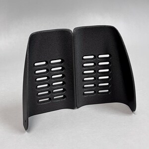 May include: A pair of black, curved, semi-rigid guards featuring a textured surface and two vertical columns of six rectangular ventilation slots each. The bottom corner of the left guard has a small circular hole. The logo GAVILAND 3D SOLUTIONS is visible.