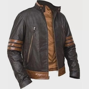 Può includere: Una giacca in pelle marrone scuro con colletto alla coreana, chiusura frontale con zip e fodera interna liscia color cuoio. Le maniche sono decorate con tre strisce orizzontali color cuoio, con orlo dello stesso colore e due tasche con cerniera.