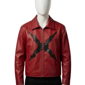 May include: A red leather jacket featuring a pointed collar, long sleeves, and a central silver zipper closure. The front of the jacket displays a large, black, cross-shaped applique with jagged, wing-like edges centered over the zipper.