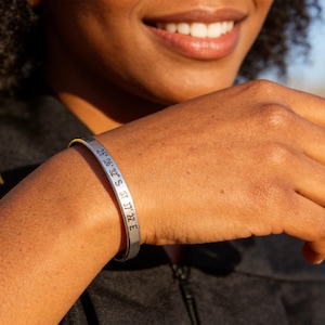 May include: A white ceramic mug with a black handle and the text "But First, Coffee" in a handwritten style. The mug is on a white surface.