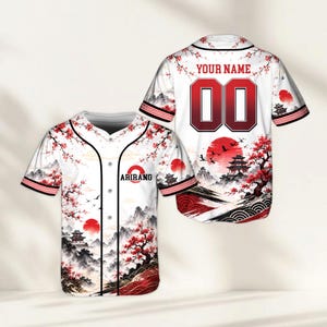 May include: A white baseball jersey featuring a red and black landscape print with cherry blossoms, mountains, and a pagoda. The front displays the text ARIRANG with a red circle, while the back shows the text YOUR NAME and the number 00.