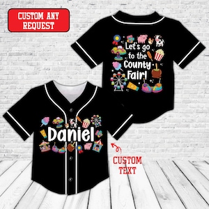 May include: A black button-down baseball jersey with white piping. The front features the name Daniel surrounded by colorful county fair graphics. The back displays the text Let's go to the County Fair! with illustrations of a pig, cow, ferris wheel, and carnival treats.