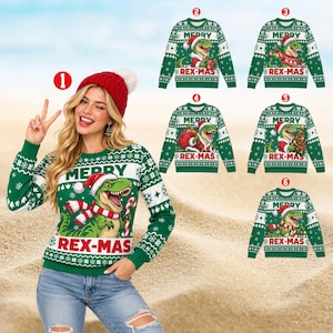 Op de afbeelding: Een groene trui met lange mouwen en een afbeelding van een T-Rex met een kerstmuts en sjaal, met de tekst MERRY REX-MAS. Het ontwerp bevat witte sneeuwvlokken en geometrische patronen. Er worden zes verschillende varianten getoond.