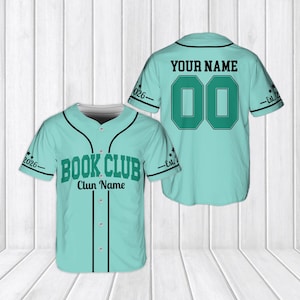 May include: A light teal baseball jersey featuring black trim, buttons, and the text "BOOK CLUB" with "Clun Name" on the front. The back displays "YOUR NAME" and the number "00" in dark green with black outlines, plus "Est. 2026" on the sleeves.