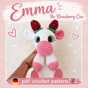 Könnte beinhalten: Ein weiß-rosa gehäkeltes Kuh-Stofftier mit großen blauen Augen und zwei roten erdbeerförmigen Hörnern auf dem Kopf. Der Text Emma the Strawberry Cow und pdf crochet pattern ist zusammen mit Herz- und Sternsymbolen auf dem Bild zu sehen.