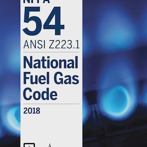 Puede incluir: Una taza de cerámica blanca con un asa negra y el texto "But First, Coffee" en negrita negra. La taza se encuentra sobre un fondo borroso, sugiriendo un ambiente acogedor.