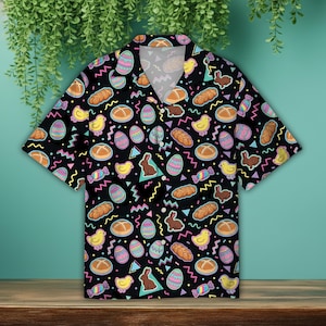 May include: Black short-sleeved button-down shirt with an all-over Easter-themed pattern. The design includes colorful eggs, chicks, bunnies, bread, and candy. The shirt has a classic collar and a relaxed fit, perfect for spring.