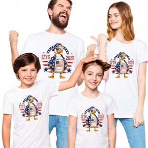 Family wearing matching America 250th anniversary shirts with patriotic eagle graphic for Fourth of July celebrations.
