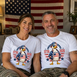 Couple wearing matching America 250th anniversary shirts with patriotic eagle graphic and Independence Day theme.