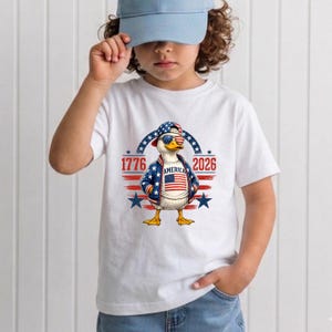 Youth wearing patriotic America 250th anniversary shirt featuring eagle artwork and 1776 2026 celebration theme.