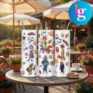 A set of three colorful tumblers featuring cartoon animal characters, such as a dog, cat, and rabbit, along with various other cartoon-themed illustrations. The tumblers are placed on a wooden table, with potted plants and umbrellas visible in the background.