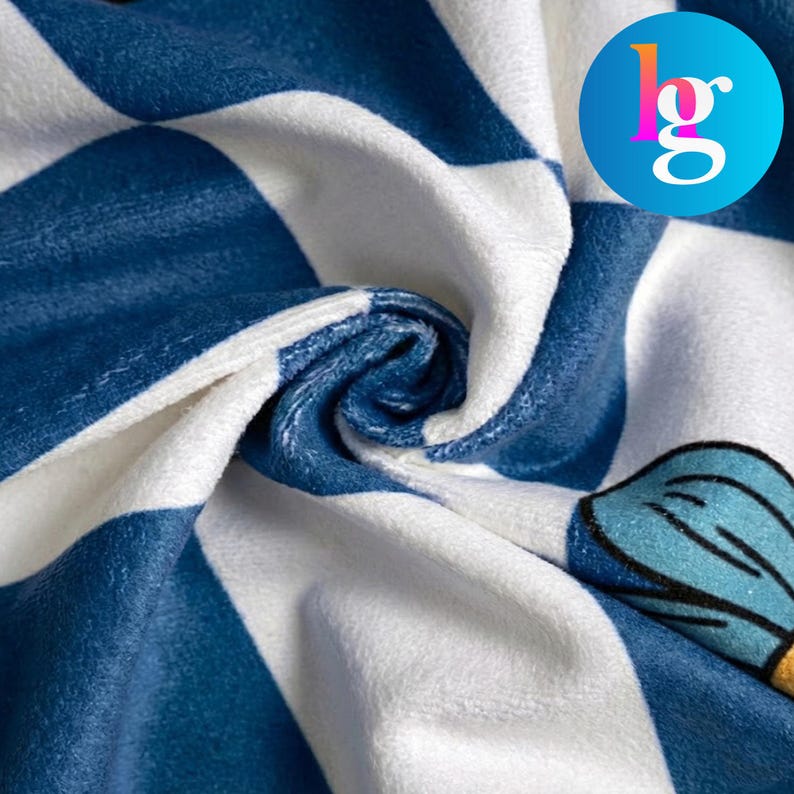 The image is a close-up of a fabric with a blue and white checkered pattern, featuring a small graphic design on the right side.